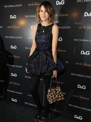 Alexa Chung wearing a sleeveless black dress with opaque tights